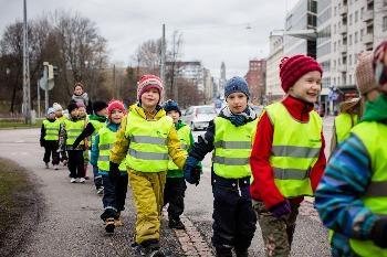 Lapset kävelee kaupungilla jonossa huomioliivit päällä