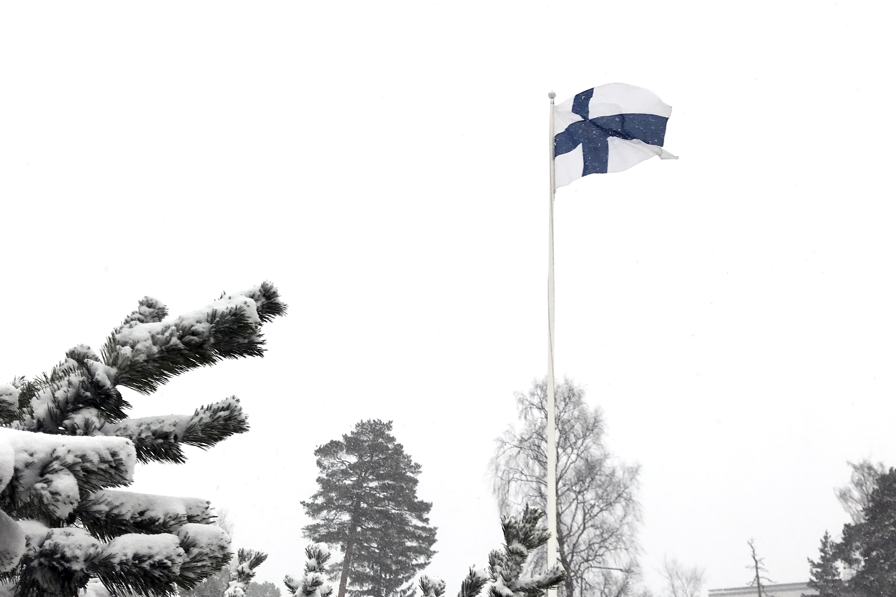 Suomen lippu lumisateessa.