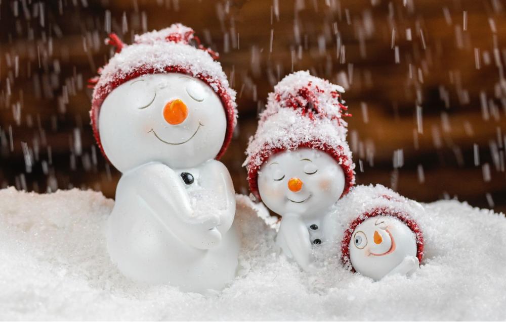 Lumiukko-perhe onnellisena lumisateessa