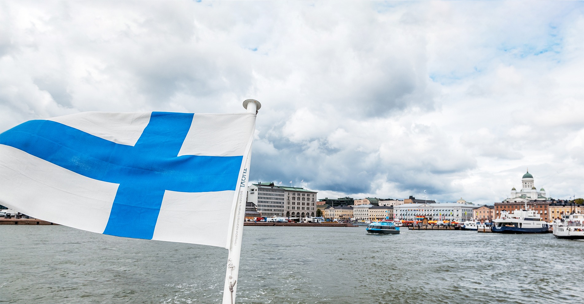 Suomen lippu veneessä Helsingin edustalla.